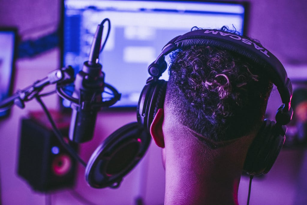 Back view of a music producer working in a vibrant recording studio setting.